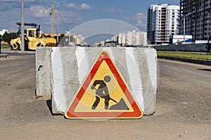A stop road sign and concrete blocks block the entrance to the construction site. Closed road. Construction and road works