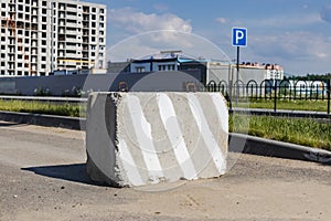 A stop road sign and concrete blocks block the entrance to the construction site. Closed road. Construction and road works