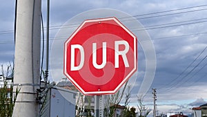 Stop road sign in Turkish - DUR - on a cloudy day