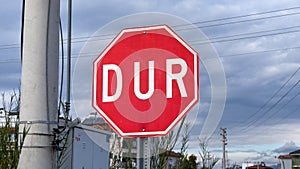 Stop road sign in Turkish - DUR - on a cloudy day photo