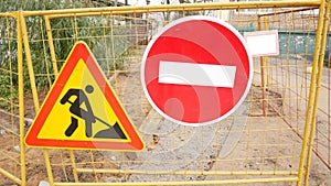 Stop and road works signs on a fence, construction and building industry.