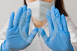 Stop SARS-CoV, SARSCoV, virus 2020 , MERS-CoV ,chinese virus COVID-19. Closeup womans hands in blue medical gloves show STOP sign