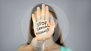 Stop sexual assault sign on womans hand, female rights protection, awareness