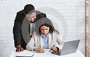 Stop sexual harassment. Perverted African American boss touching his attractive female assistant at office