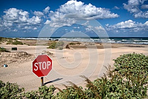 A stop sign buried in the sand