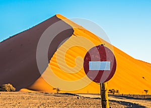 Stop sign in front of sand dune in Sossusvlei, Namib-Naukluft Na