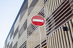 Stop sign near new parking building, empty street nobody concept