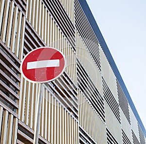 Stop sign near new parking building, empty street nobody concept