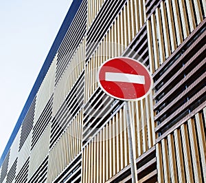 Stop sign near new parking building, empty street nobody concept