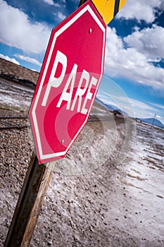 Stop sign (pare) at railway crossing in a desolate landscape