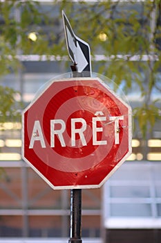 Stop sign reading "arret" on the city street