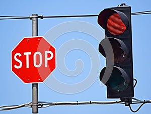 Stop sign and red light at the road crossing