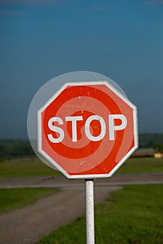 Stop sign on a rural road. Selective focus with shallow depth of field