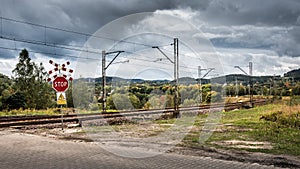 Stop sign, unguarded railroad crossing in Walbrzych, in the distance you can see the mountains photo