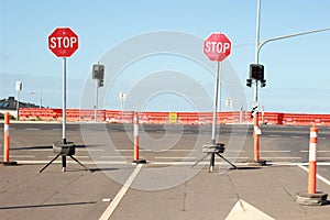 Stop signs and various warning signs warning oncoming traffic of the end of the road on a highway still under construction in