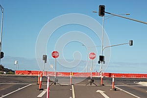 Stop signs and various warning signs warning oncoming traffic of the end of the road on a highway still under construction in