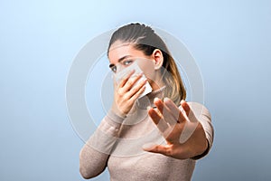 Stop spreading coronavirus. young woman holding a napkin as a virus protective mask and raised hand asking to keep