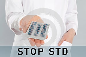 STOP STD. Doctor with pills on light grey background, closeup
