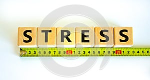 Stop stress and be health symbol. Wooden cubes with the word `stress` behind yellow ruler. Beautiful white background.