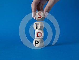 Stop symbol. Concept word Stop on wooden cubes. Businessman hand. Beautiful blue background. Business and Stop concept. Copy space