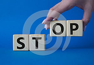 Stop symbol. Concept word Stop on wooden cubes. Businessman hand. Beautiful blue background. Business and Stop concept. Copy space