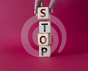 Stop symbol. Concept word Stop on wooden cubes. Businessman hand. Beautiful red background. Business and Stop concept. Copy space