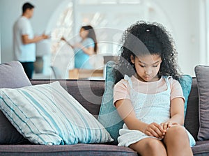 Stop and take note of whos watching. a little girl looking sad on a sofa while her parents argue in the background.