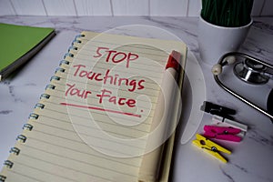 Stop Touching Your Face write on a book and keyword isolated on Office Desk. Healthcare/Medical Concept