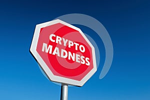 Stop traffic sign with a text CRYPTO MADNESS which wants to protest against cryptocurrencies
