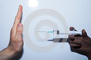 Stop vaccinations. A syringe in the doctor hand and a patient says no. photo