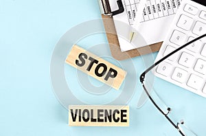 STOP VIOLENCE text written on wooden block with clipboard ,eye glasses and calculator Business concept