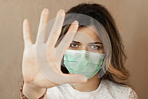 Stop the virus and epidemic diseases. Healthy woman in blue medical protective mask showing gesture