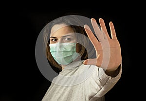 Stop the virus and epidemic diseases. Healthy woman in blue medical protective mask showing gesture stop.