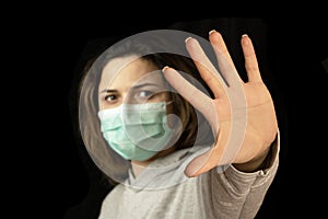 Stop the virus and epidemic diseases. Healthy woman in blue medical protective mask showing gesture stop.