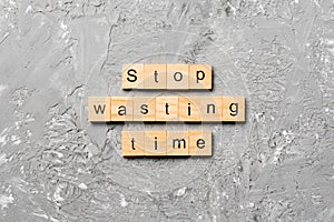 Stop wasting time word written on wood block. Stop wasting time text on cement table for your desing, Top view concept