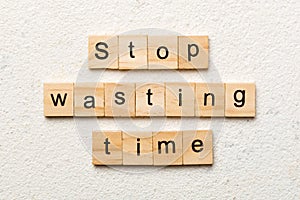 Stop wasting time word written on wood block. Stop wasting time text on cement table for your desing, Top view concept