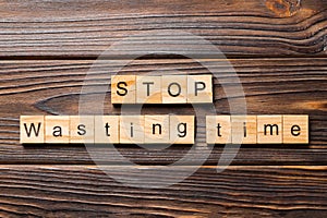 Stop wasting time word written on wood block. Stop wasting time text on wooden table for your desing, Top view concept