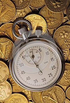 Stop watch on heaped of gold coins photo