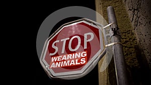 Stop wearing animals red sign on street, wildlife protection campaign message