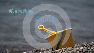 Stop wishing, start doing sentence. Toy bucket shovel on the beach