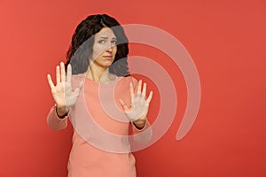 Stop it: woman with refusal or denial hand gesture with disgust or scared face expression on red