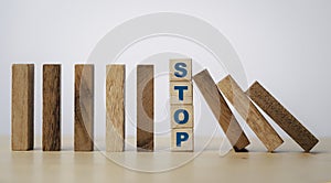 Stop wording print on wooden block cube protect wooden falling domino for risk management concept