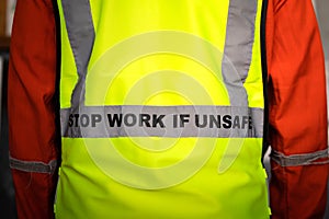 `Stop work if unsafe` on reflective vest for worker.