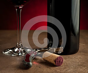 Stopper on corkscrew near bottle and wine glass