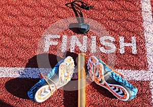 Stopwatch, baton and spikes at finish line