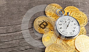 Stopwatch and bitcoin. Cryptocurrency gold coins and time on a wooden table. Fast money on bitcoin. Template Copy space