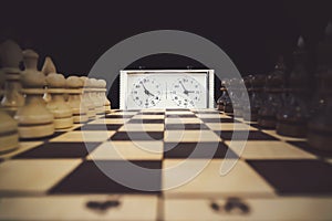 A stopwatch and a chessboard with a game in progress The beginning of the chess game. the first move
