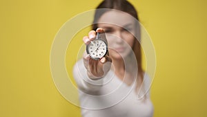 Stopwatch in foreground in hand of attractive young woman. stopwatch counts down from zero. Retro old vintage clock