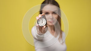 Stopwatch in foreground in hand of attractive young woman. stopwatch counts down from zero. Retro old vintage clock