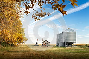 Storage bins and grain augers in a farmyard after fall harvest on the Canadian prairies in Kneehill County Alberta Canada